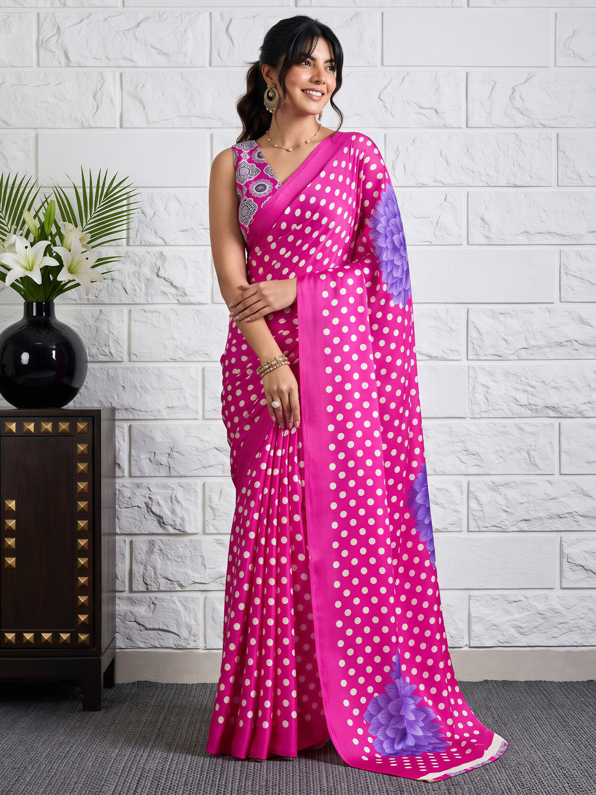 Woman wearing magenta satin saree with polka dot pattern and magenta blouse