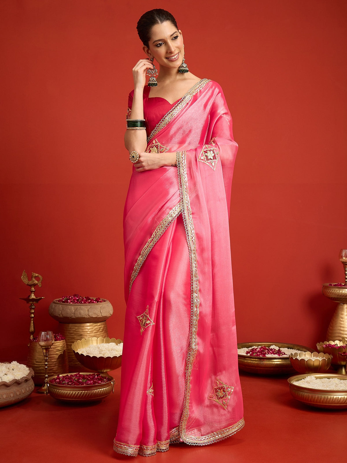 Woman wearing pink paper silk saree with ornamented surface design and pink blouse