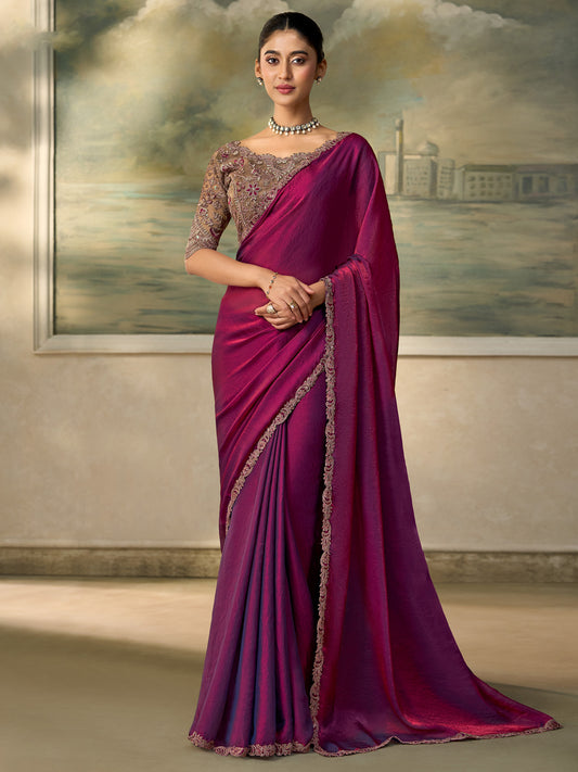 Woman wearing purple satin silk saree with embroidered motif work and grey blouse