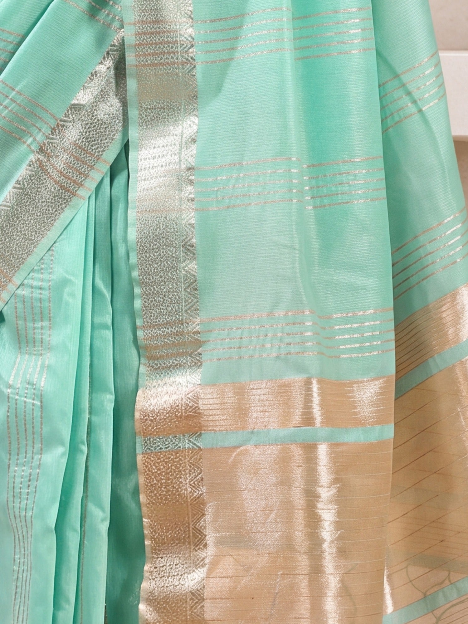 Pallu detail of turquoise linen saree showing zari butta (metallic motif) work and zari border