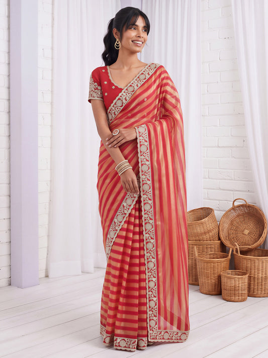 Woman wearing maroon net saree with embroidered motif work and maroon blouse