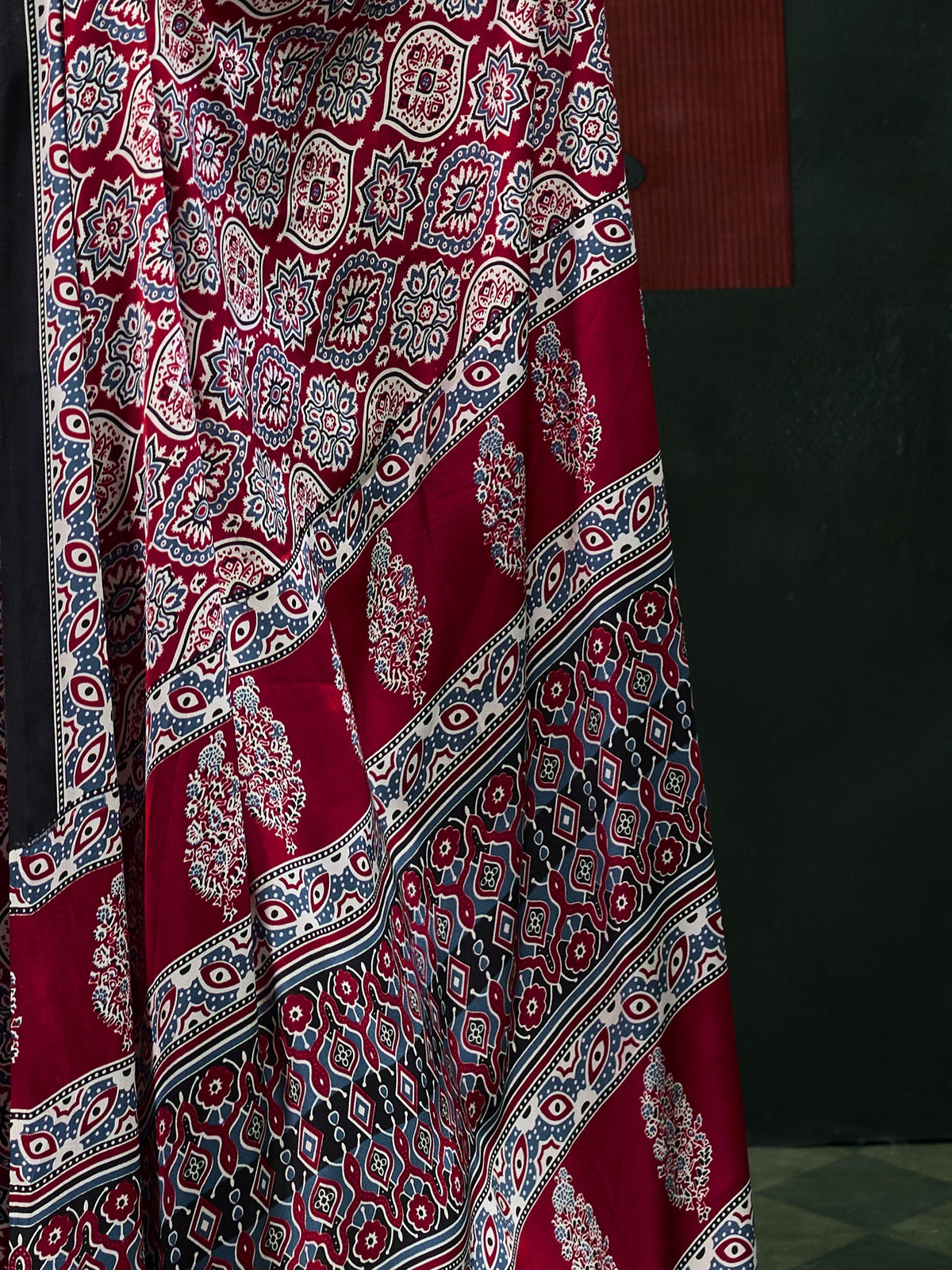 Pallu detail of maroon satin saree showing ajrak block-print motif work and printed border