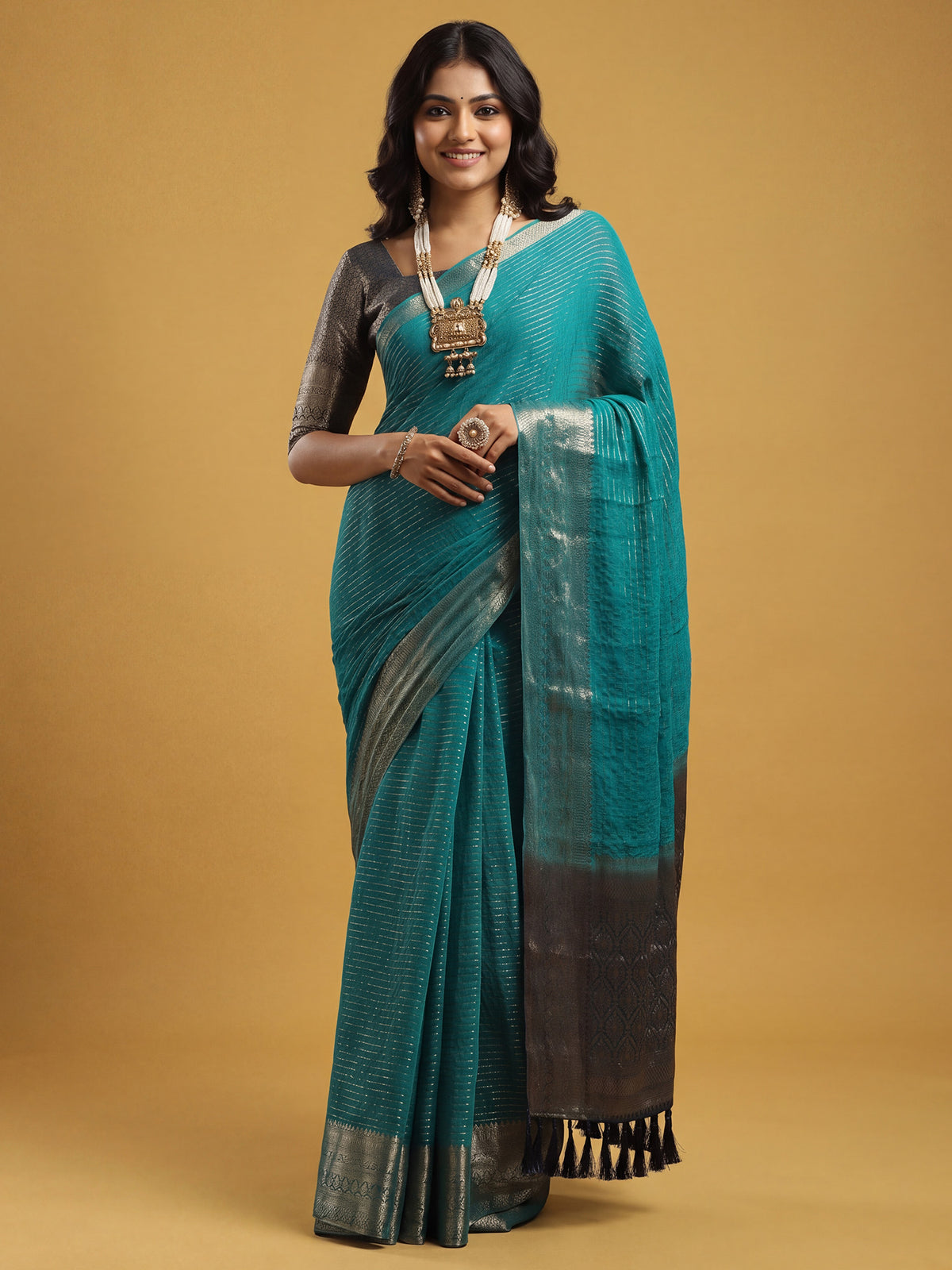 Woman wearing teal blue chiffon saree with striped pattern design and navy blue blouse