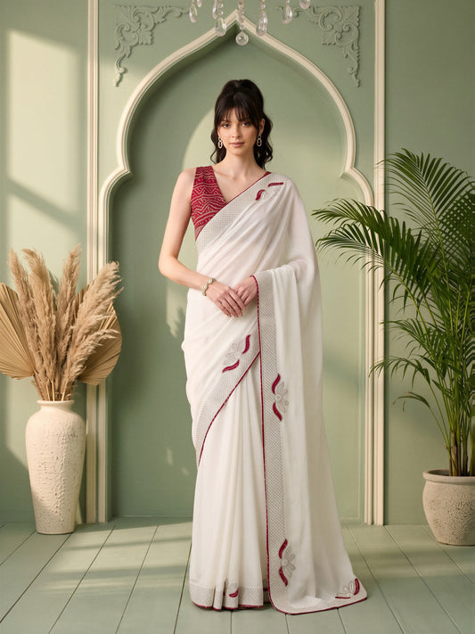 Woman wearing white vichitra silk saree with ornamented surface design and maroon blouse