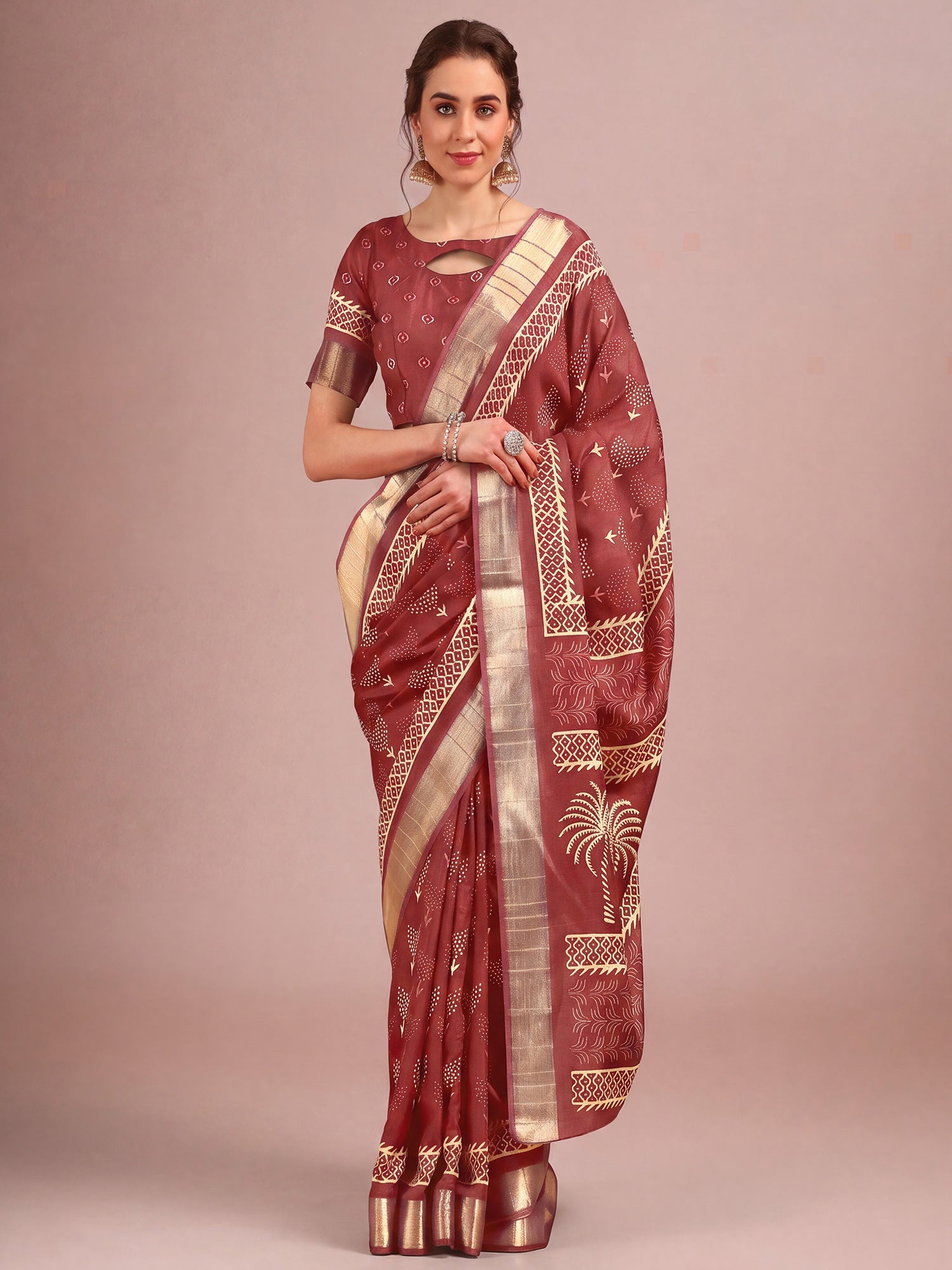 Woman wearing rust cotton silk saree with traditional indian motif work and rust blouse