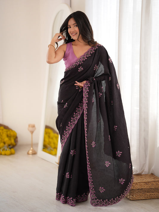 Woman wearing black poly georgette saree with ornamented surface design and lavender blouse