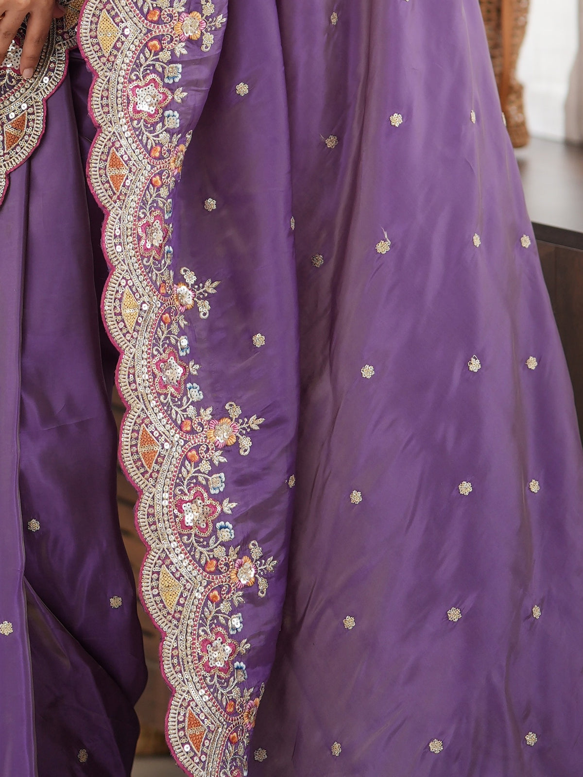 Pallu detail of lavender satin saree showing ornamented surface design and scallop border
