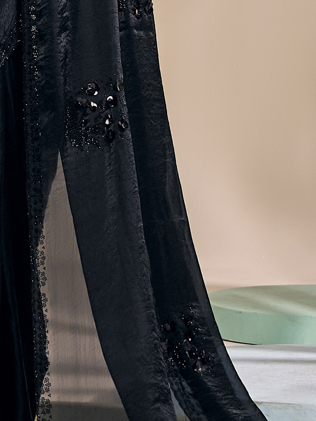 Pallu detail of black satin silk saree showing ornamented surface design and scallop border