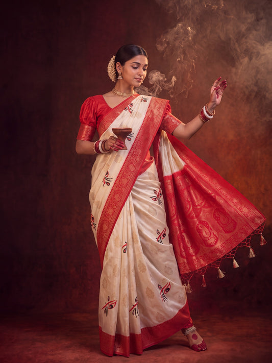 Woman wearing off white satin silk saree with all-over floral design and red blouse