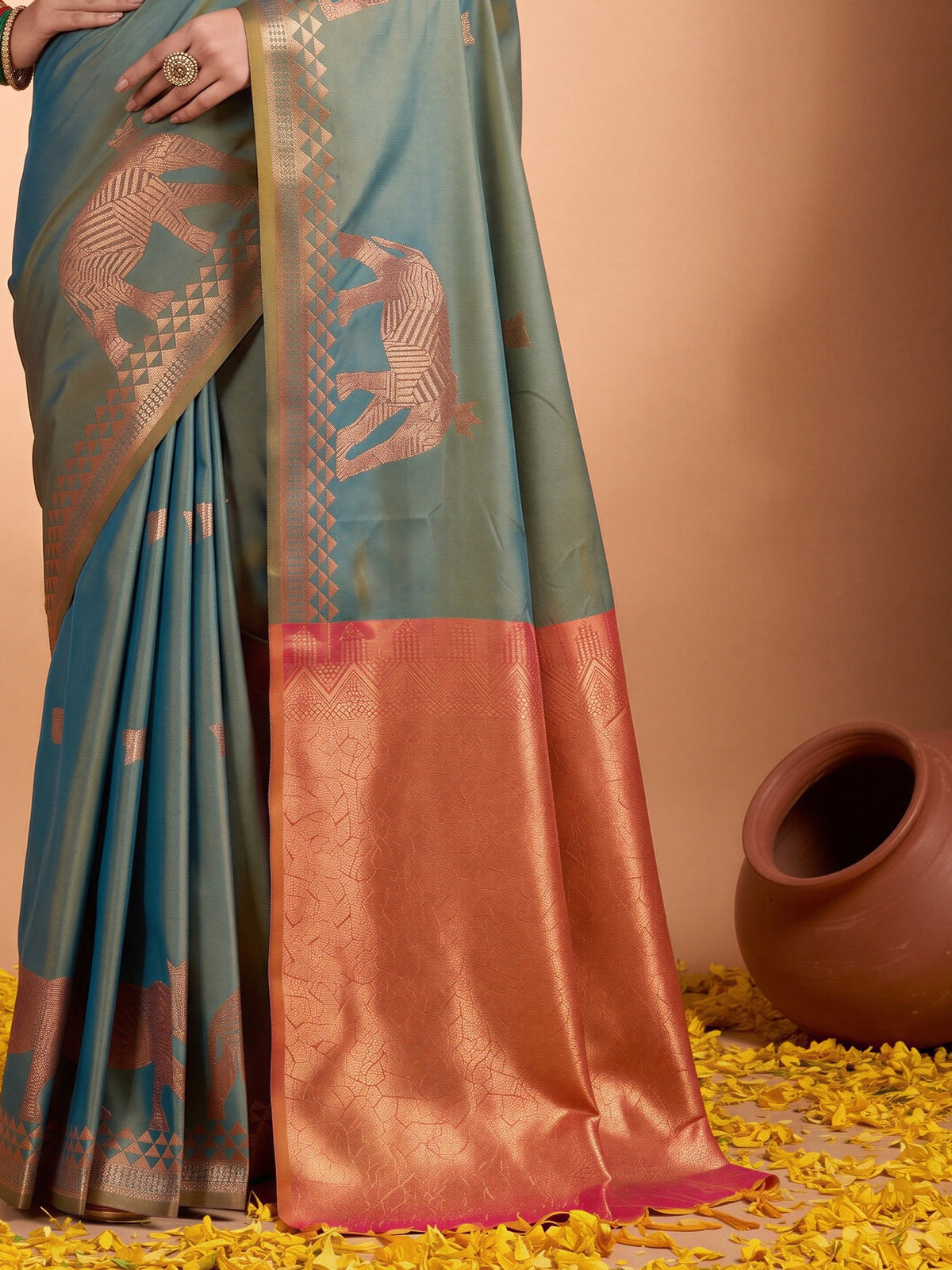 Pallu detail of teal blue silk saree showing animal-print design and zari border