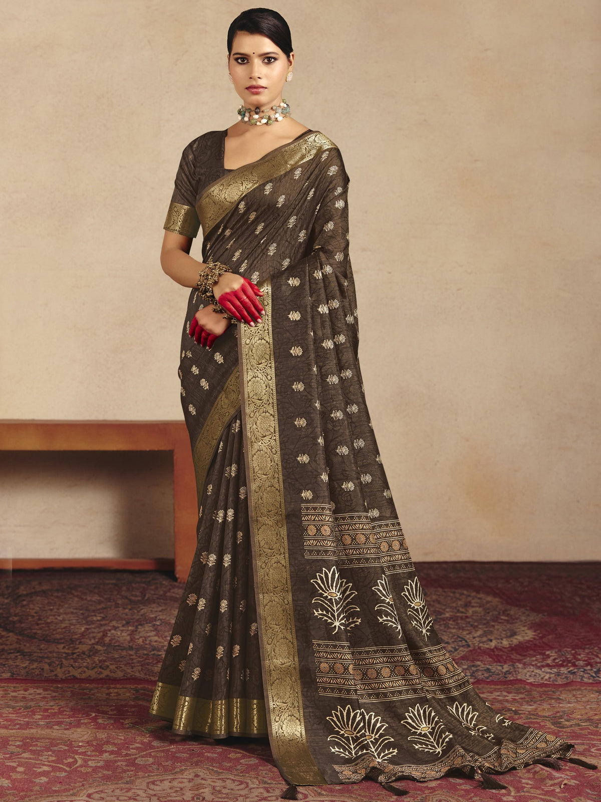 Woman wearing brown tussar silk saree with traditional indian motif work and brown blouse