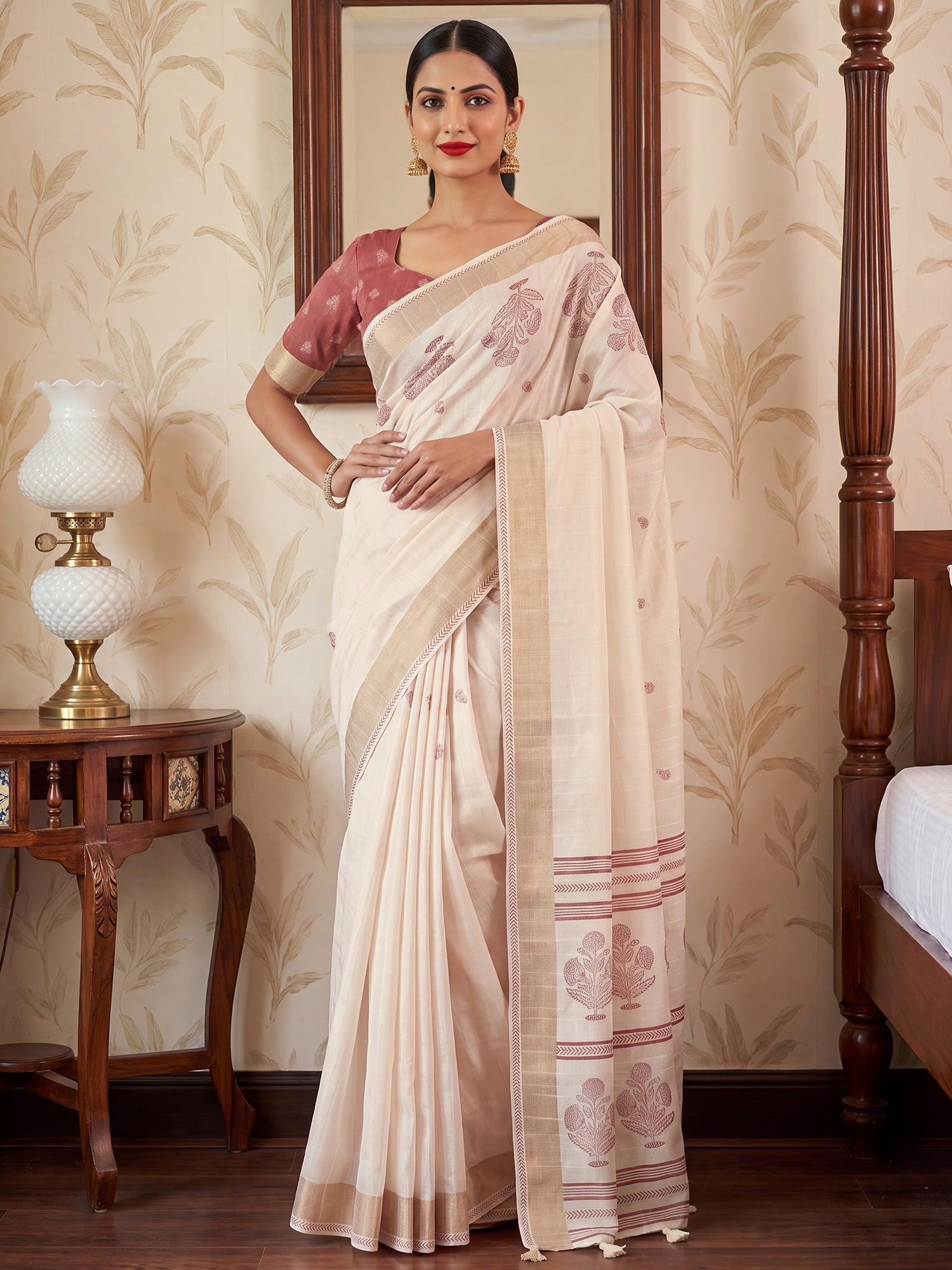 Woman wearing white satin silk saree with traditional indian motif work and mauve blouse