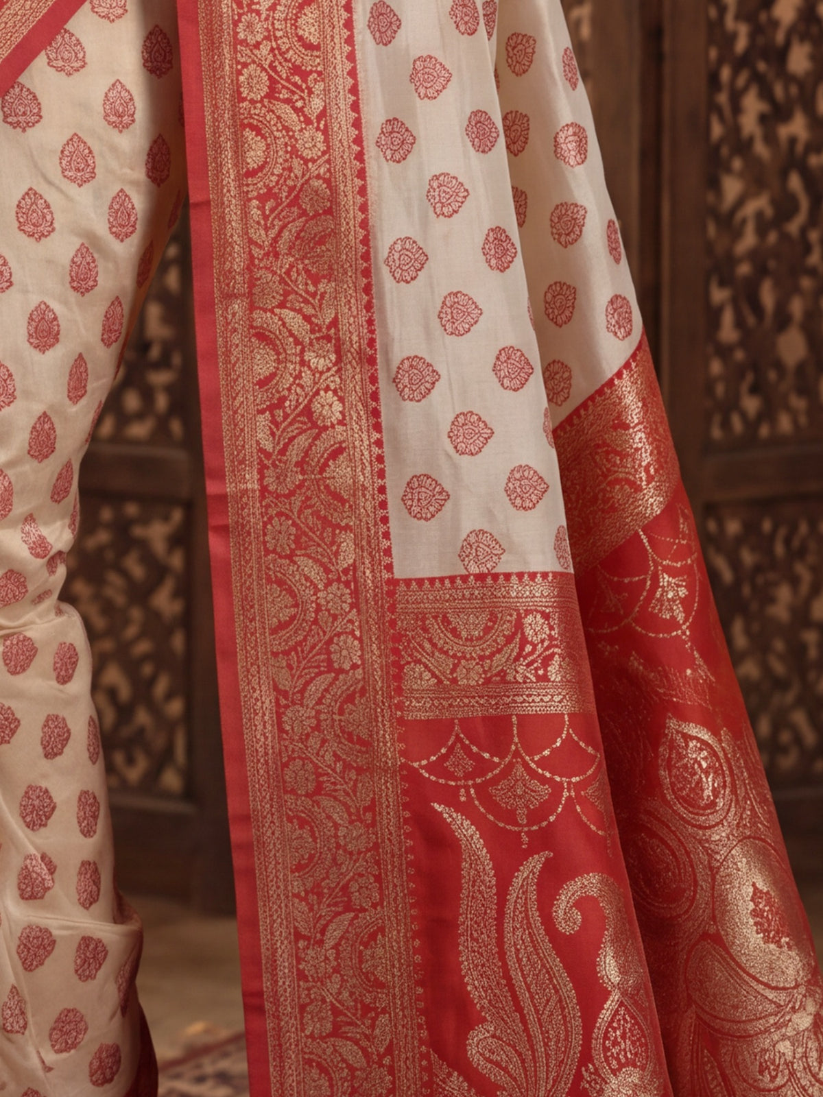 Pallu detail of white banarasi silk saree showing zari butta (metallic motif) work and zari border