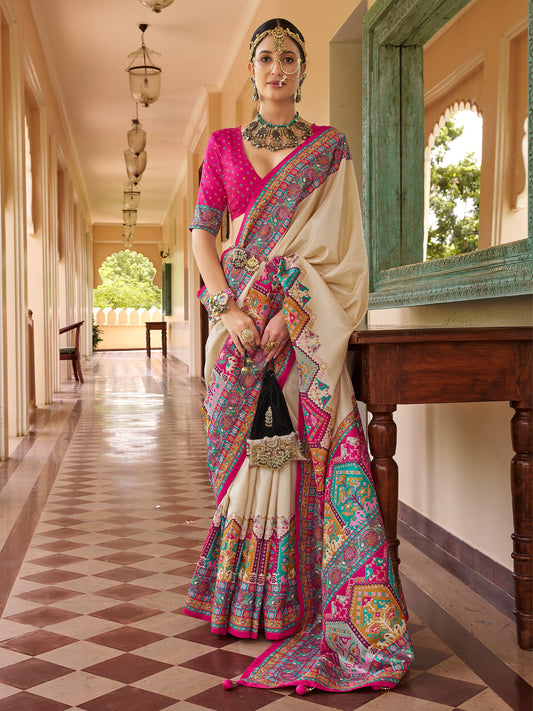 Woman wearing beige silk blend saree with traditional indian motif work and pink blouse