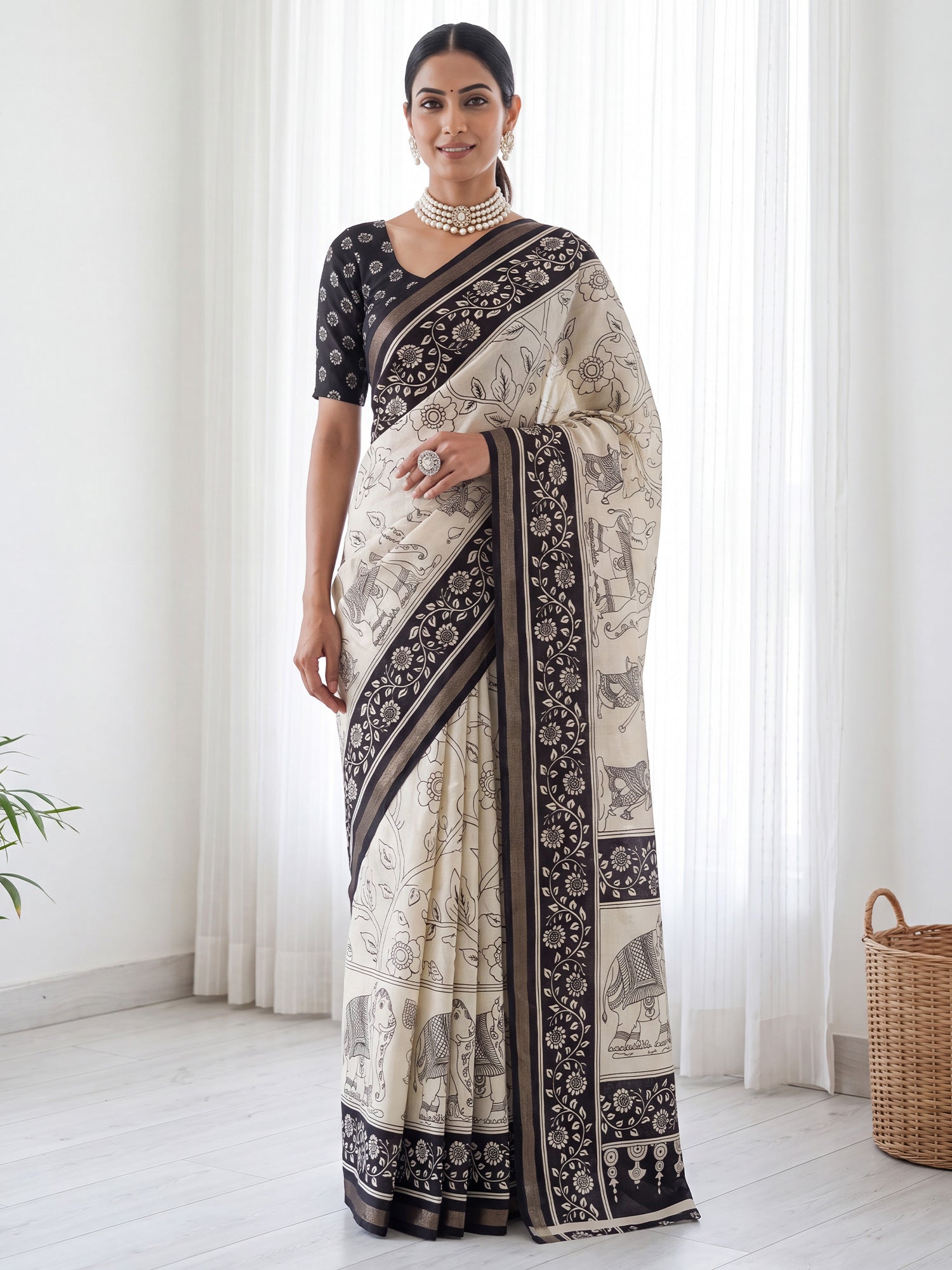 Woman wearing beige mulmul saree with kalamkari narrative motif work and black blouse