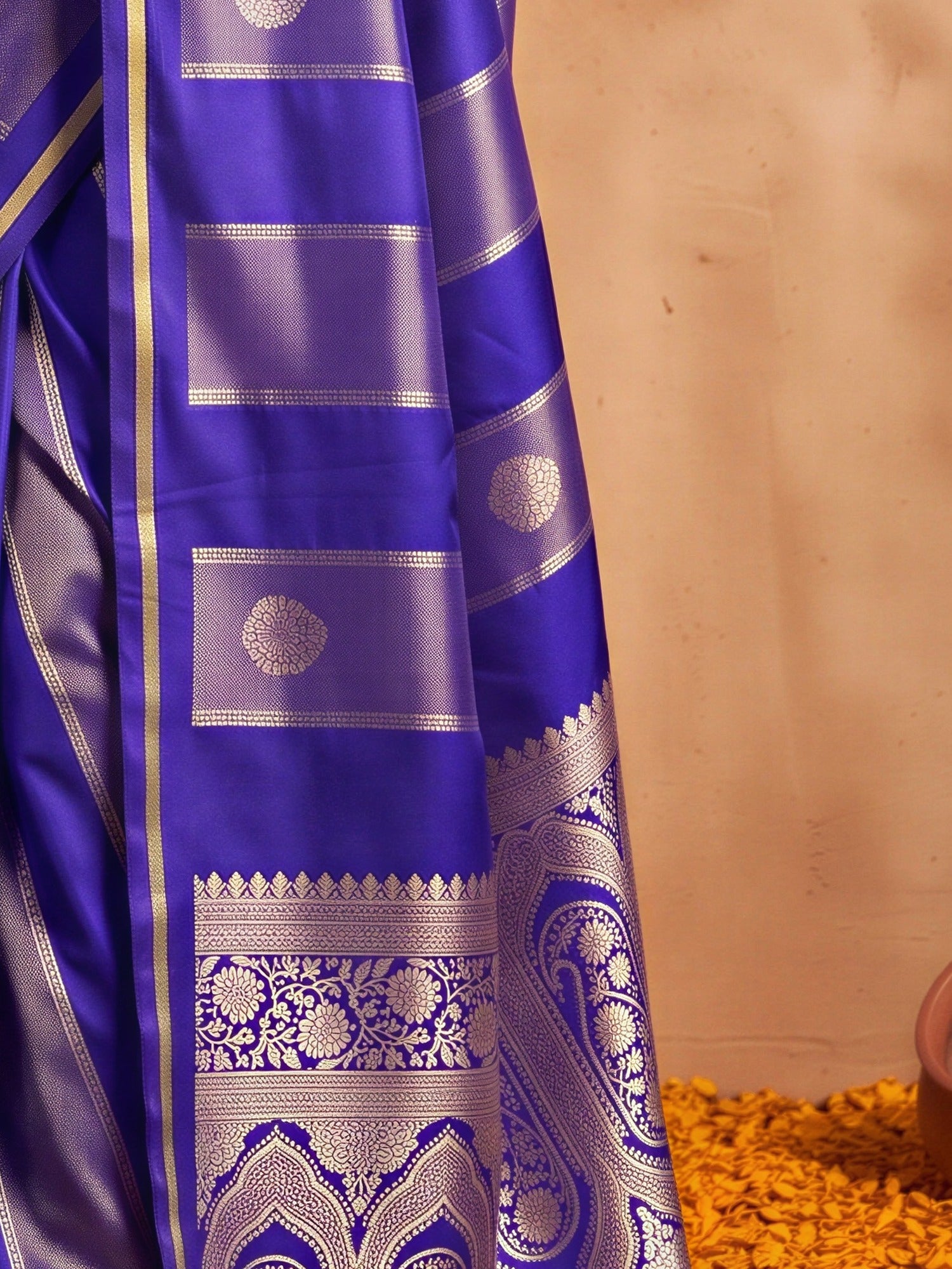 Pallu detail of blue satin saree showing traditional indian motif work and zari border