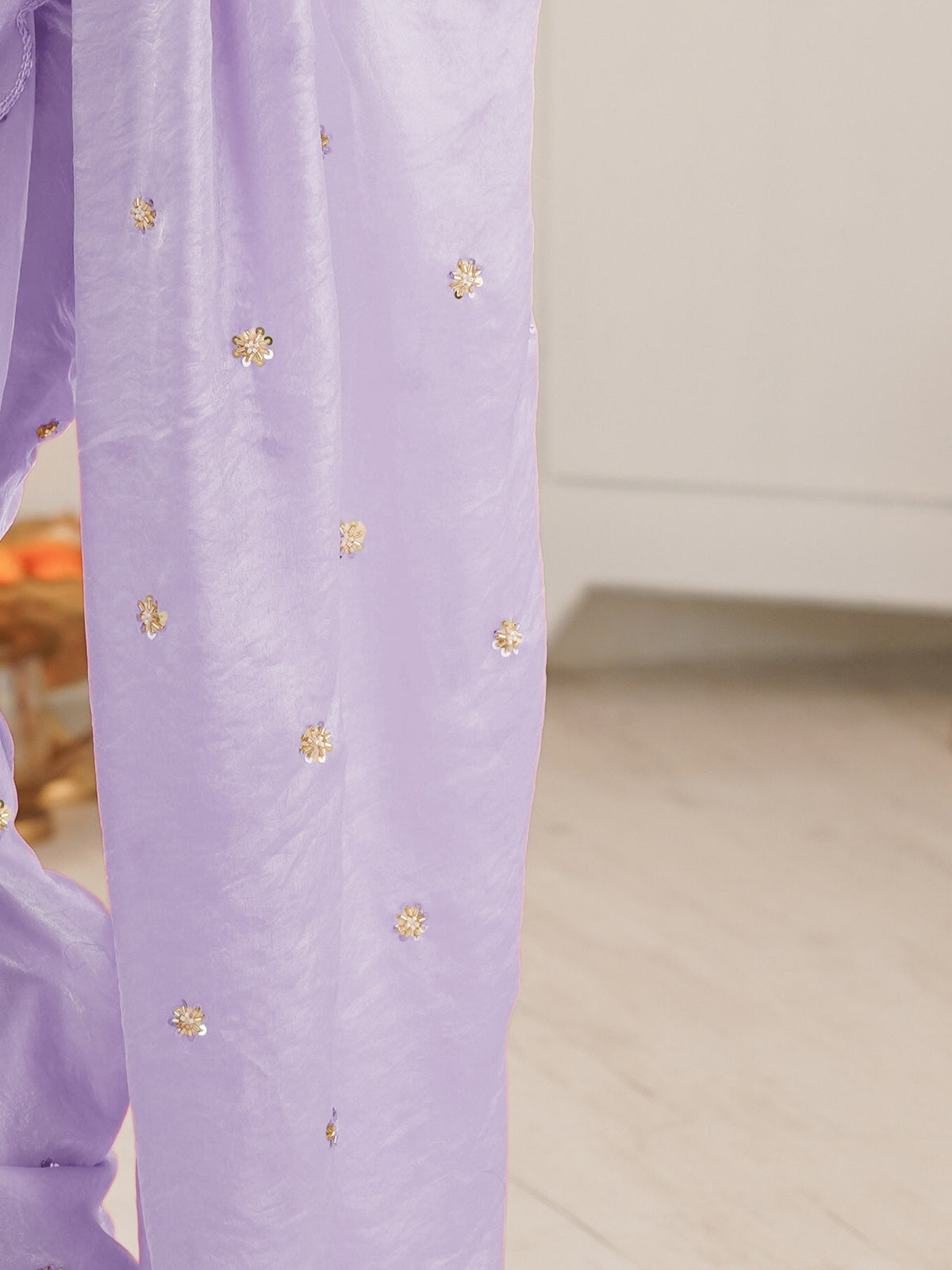Pallu detail of lavender satin saree showing ornamented surface design and embroidered border