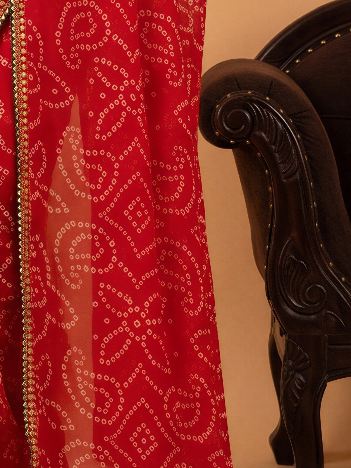 Pallu detail of red georgette saree showing bandhani tie-dye dot work and embellished border
