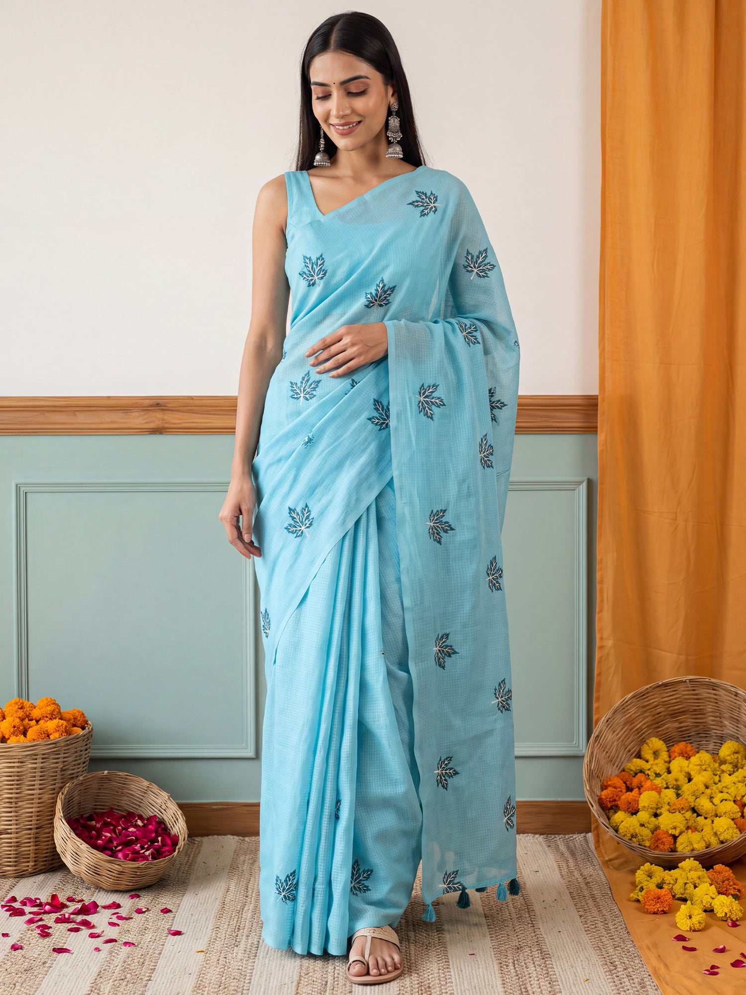 Woman wearing light blue kota doria cotton saree with embroidered motif work and light blue blouse