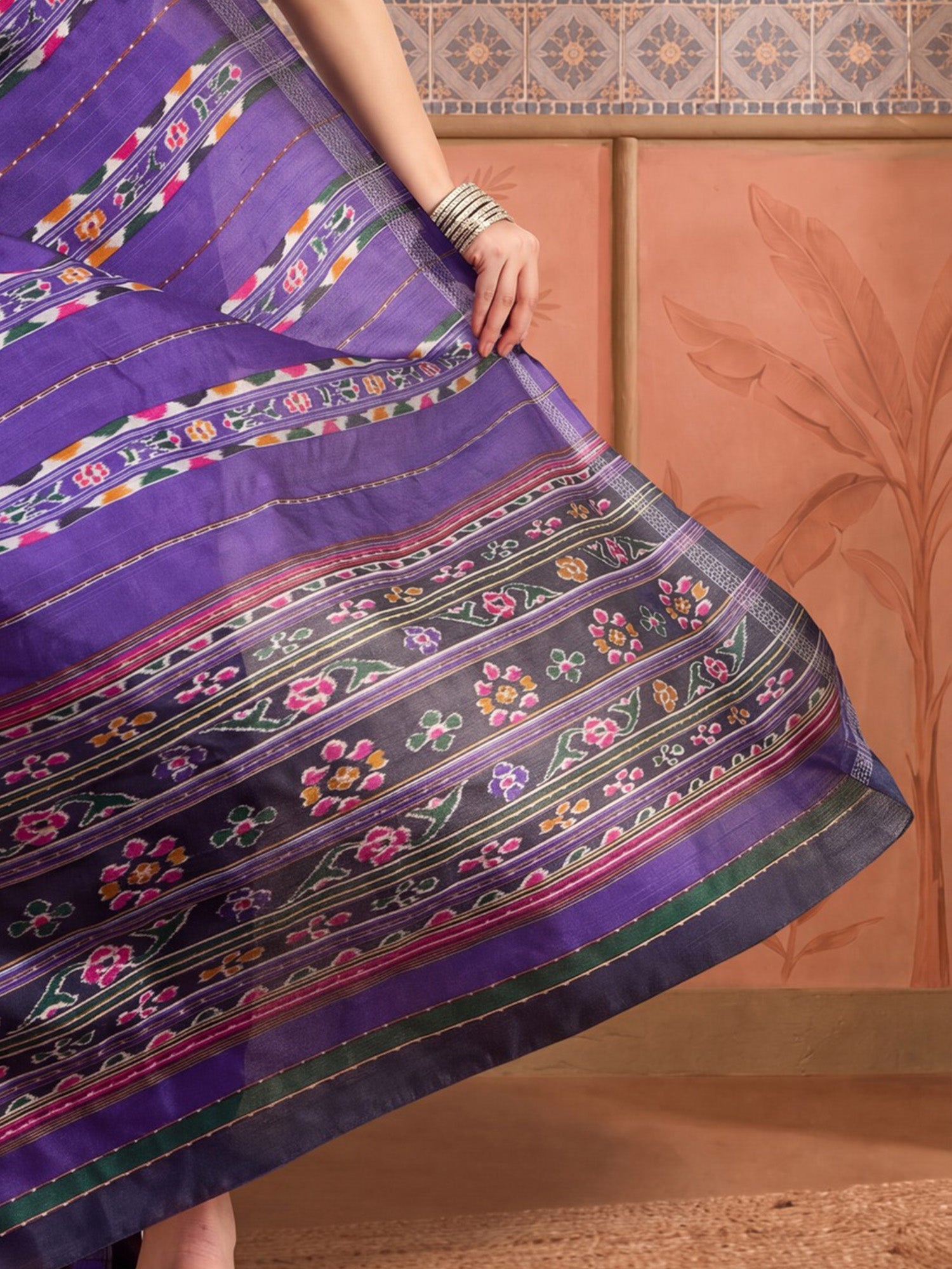 Pallu detail of purple bhagalpuri silk saree showing ikat resist-dyed pattern and printed border