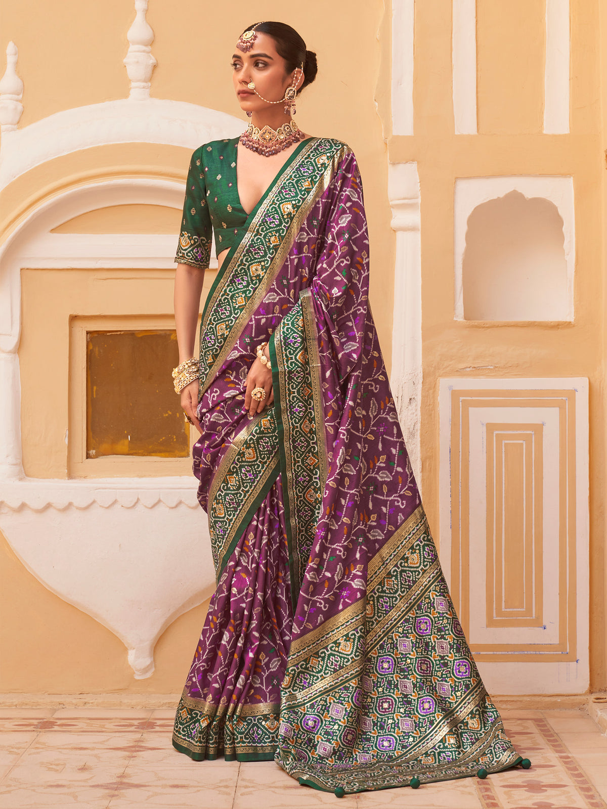 Woman wearing purple silk blend saree with ikat resist-dyed pattern and dark green blouse