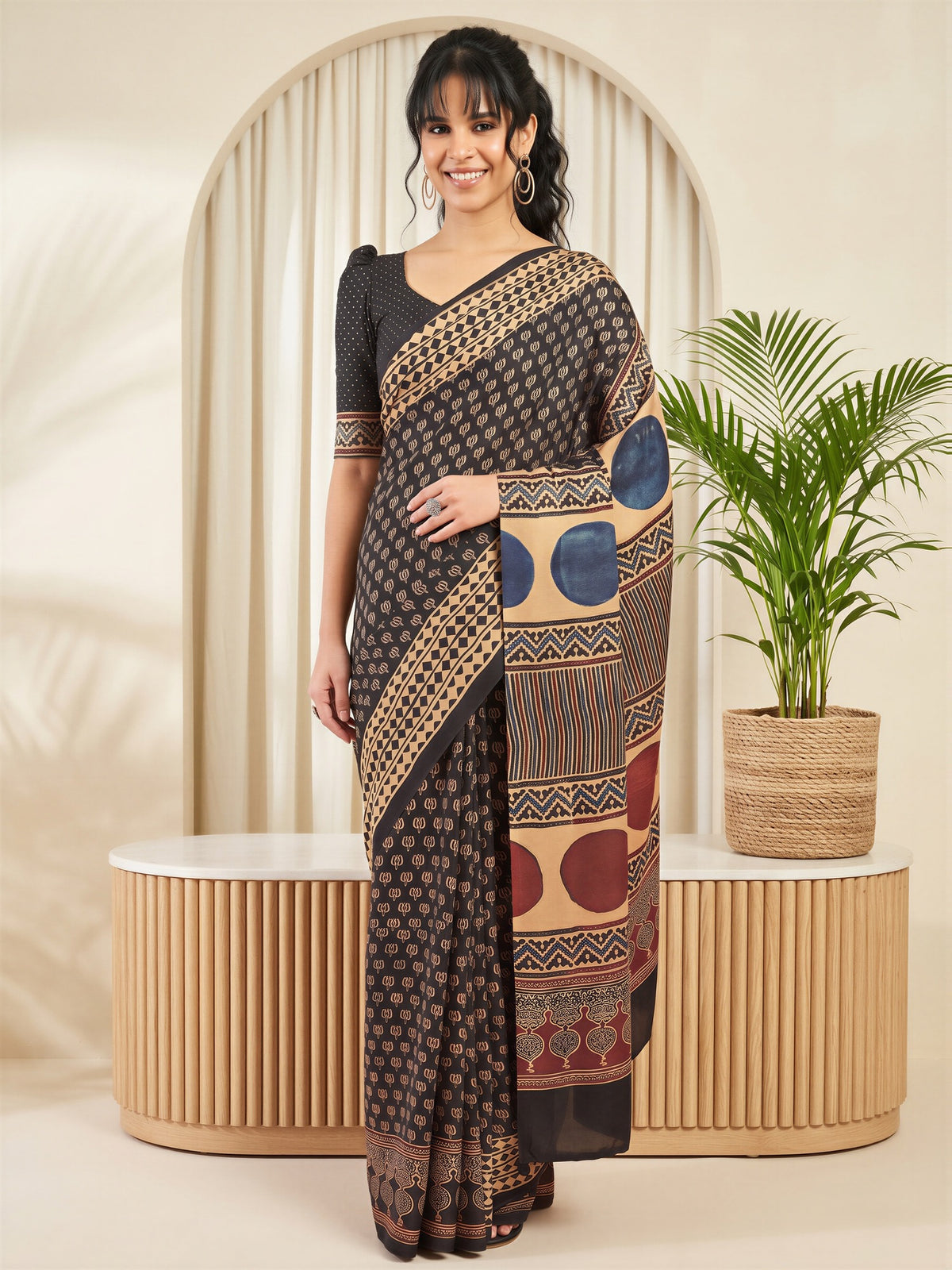 Woman wearing black silk blend saree with traditional indian motif work and black blouse