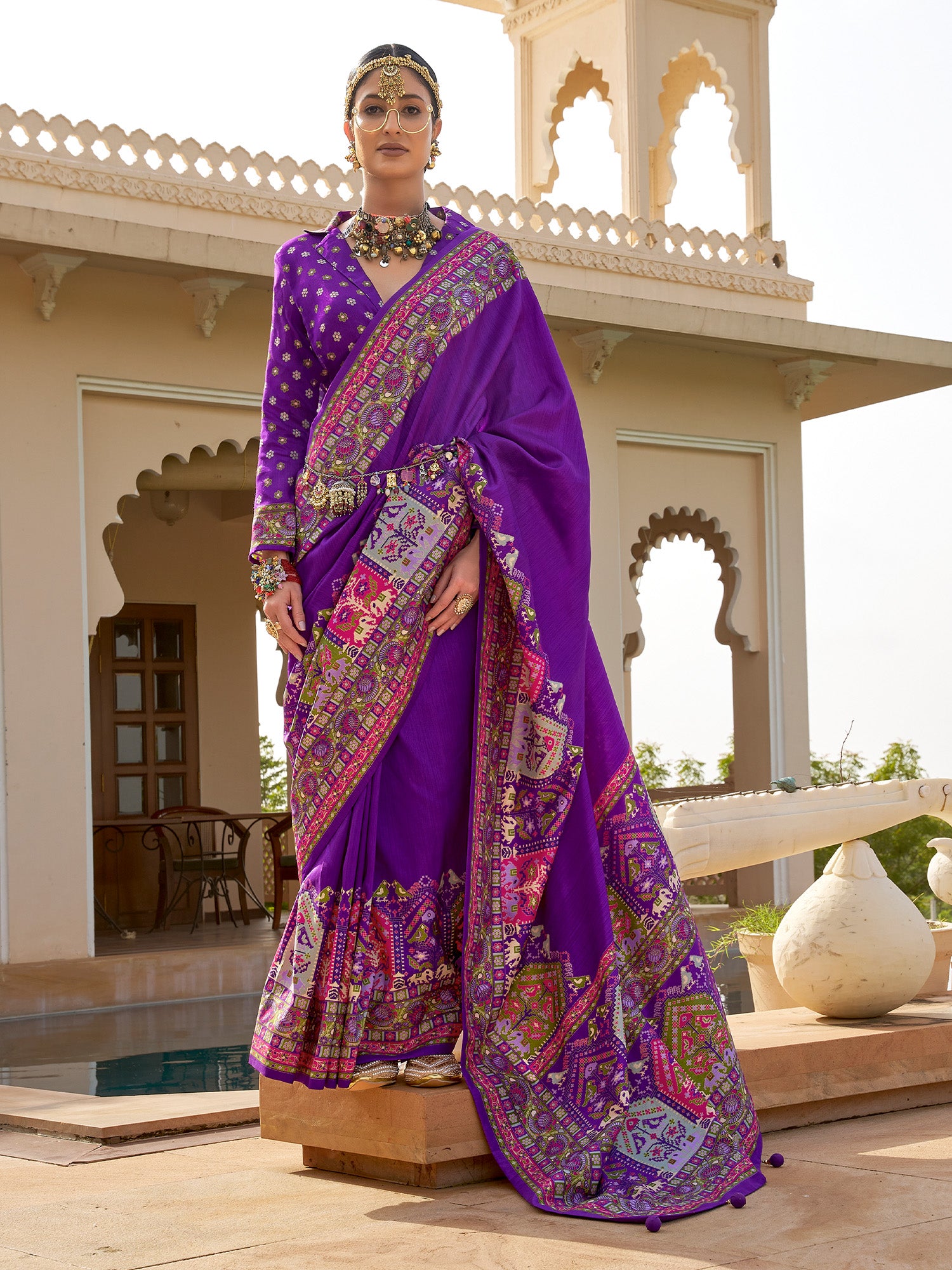 Woman wearing violet silk blend saree with kalamkari narrative motif work and violet blouse