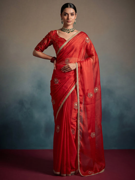 Woman wearing red pure georgette saree with ornamented surface design and red blouse