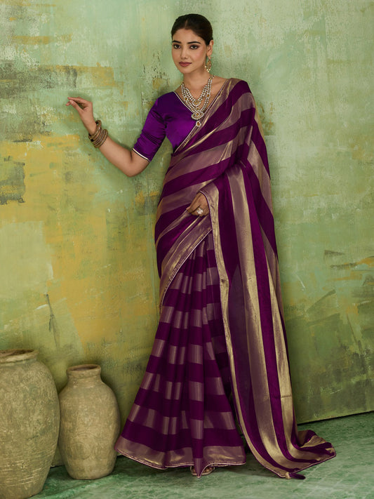 Woman wearing violet satin silk saree with colour-blocked design and violet blouse