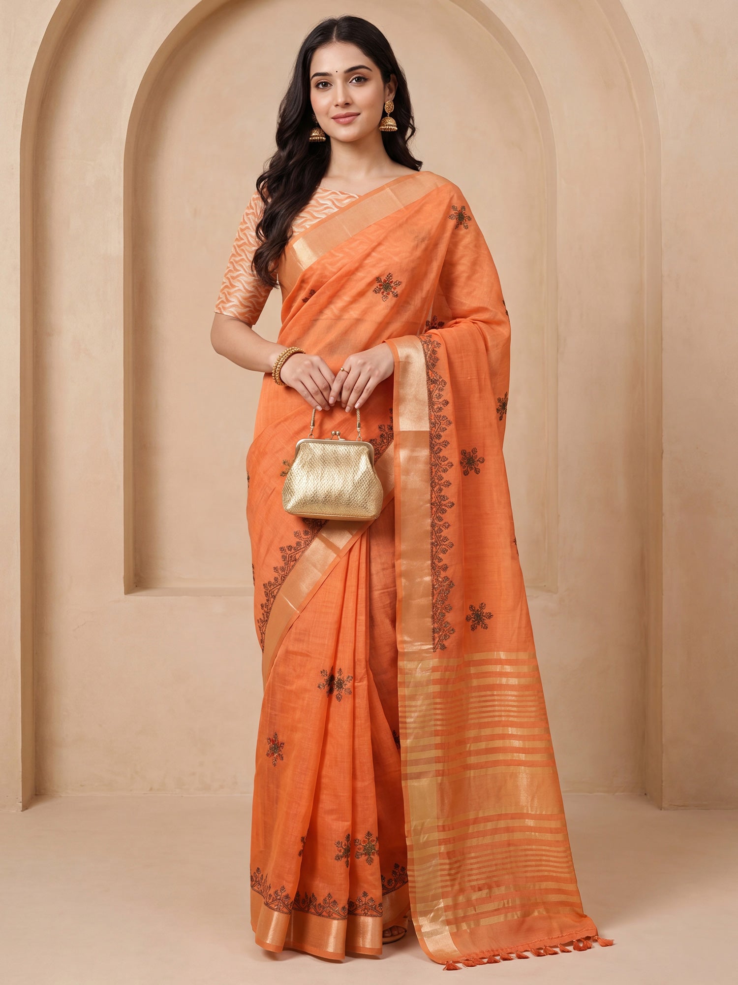Woman wearing orange cotton linen saree with embroidered motif work and orange blouse