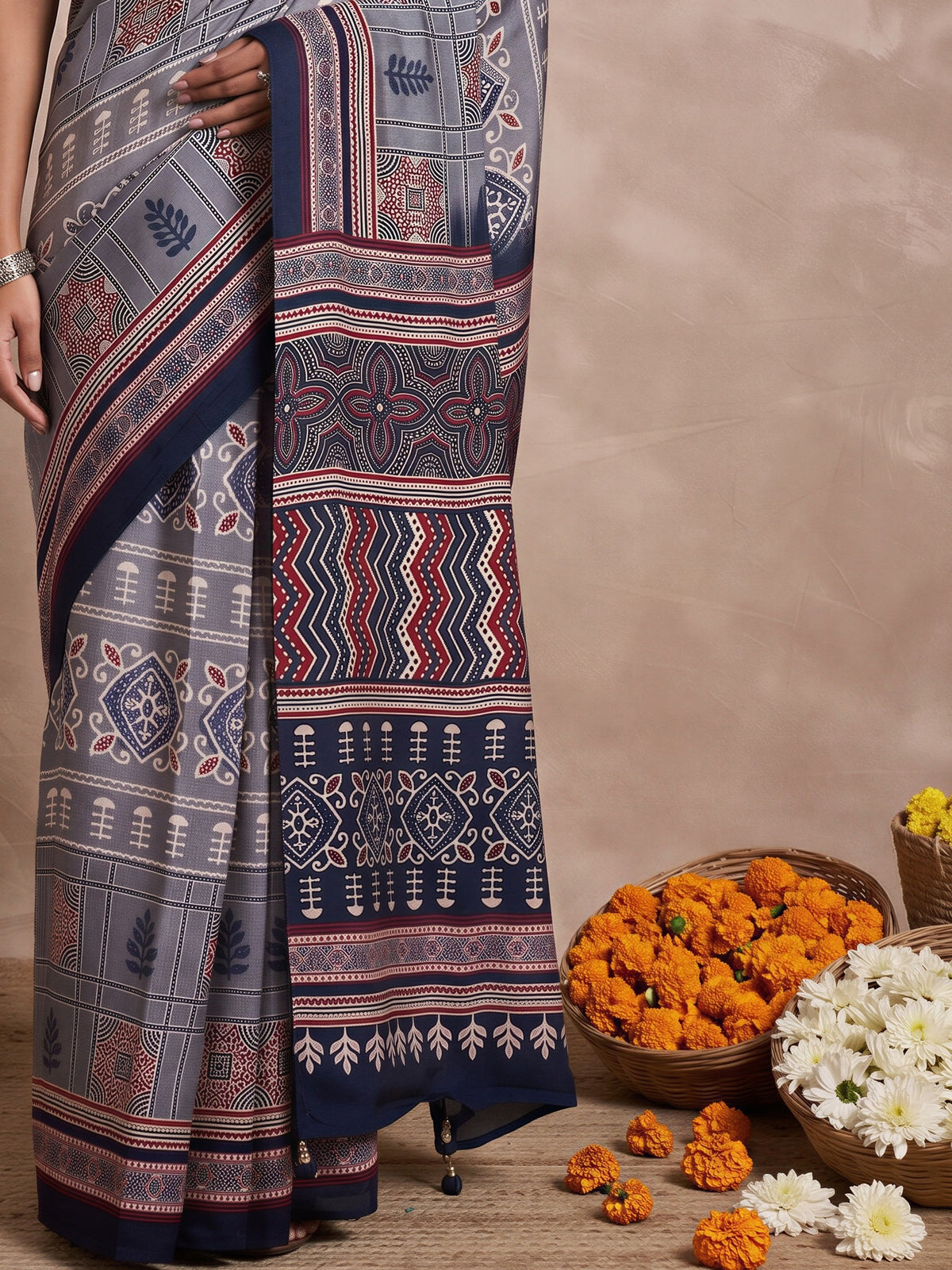 Pallu detail of grey viscose silk saree showing traditional indian motif work and printed border