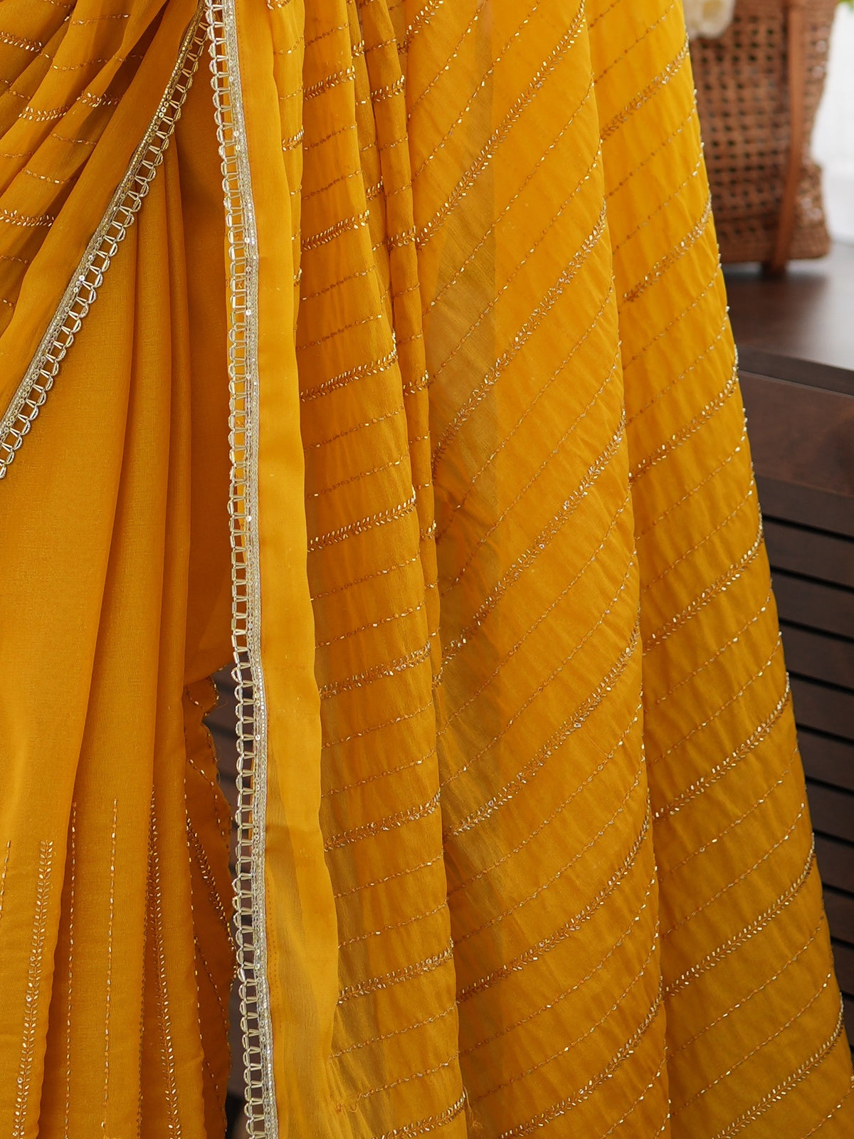 Pallu detail of mustard georgette saree showing ornamented surface design and embellished border