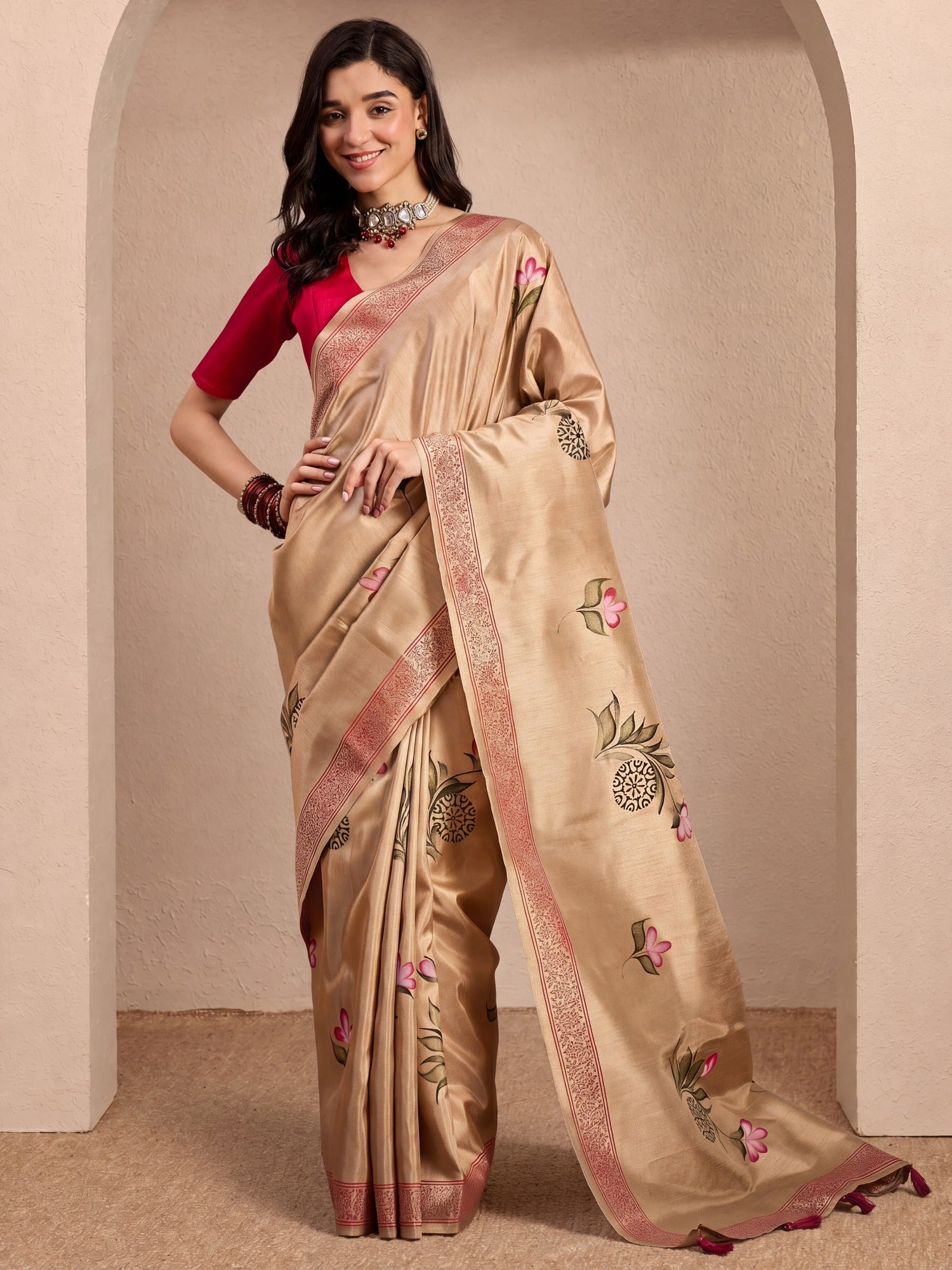 Woman wearing beige silk blend saree with hand-painted motif work and pink blouse