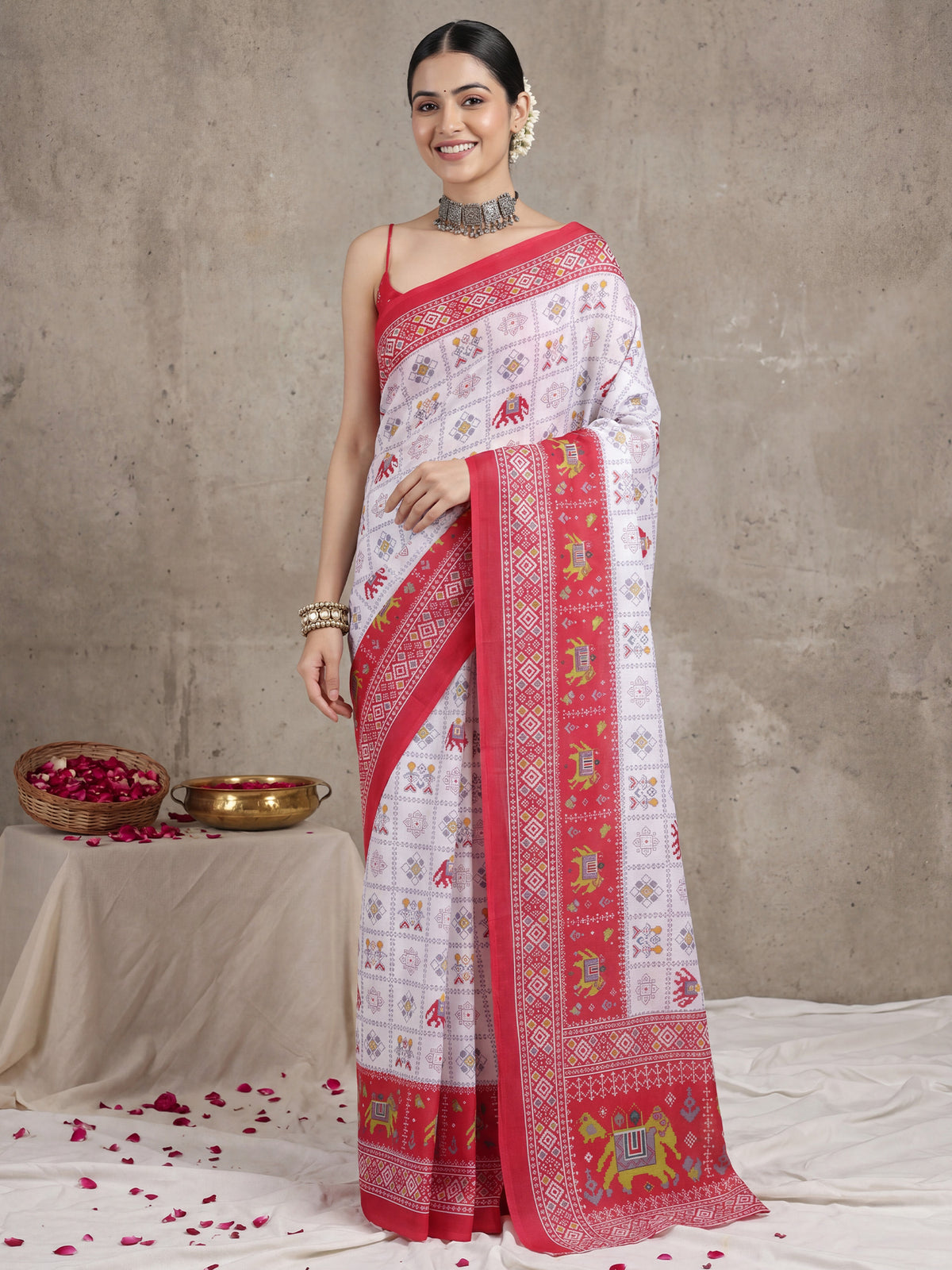 Woman wearing white cotton saree with traditional indian motif work and pink blouse