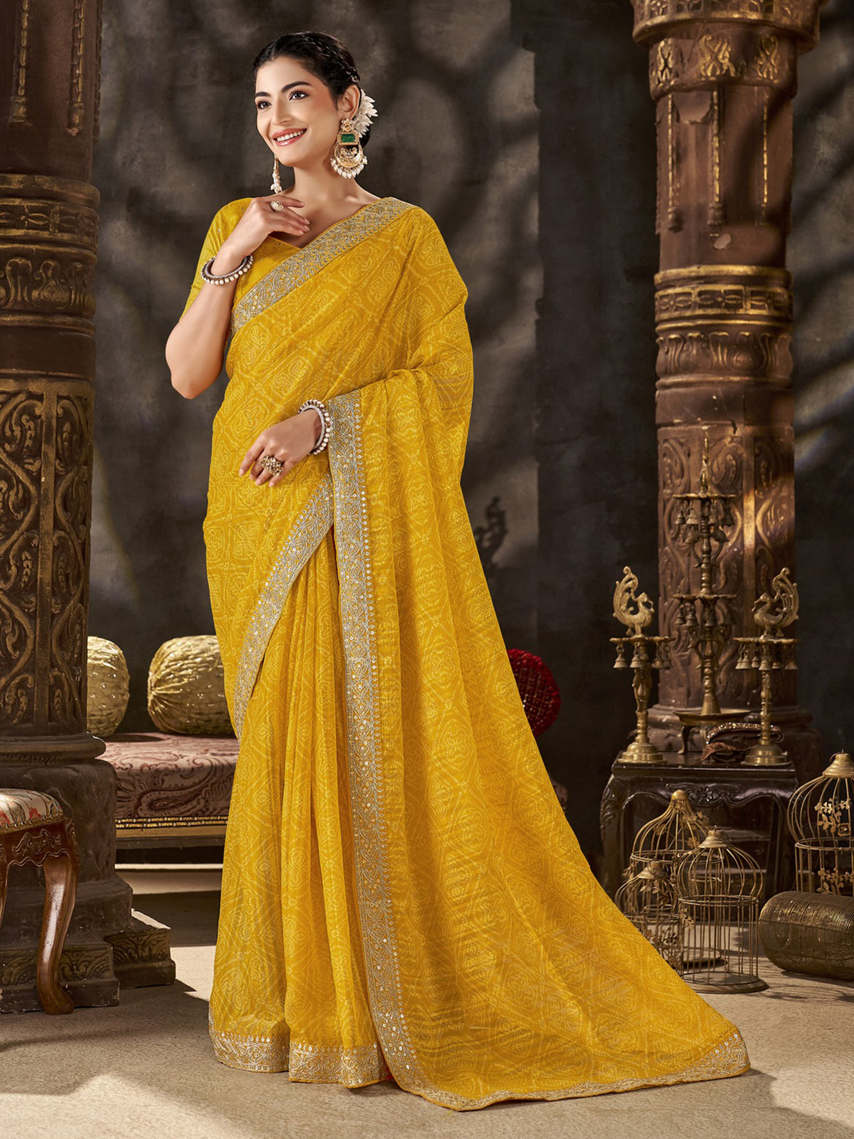Woman wearing yellow chiffon saree with bandhani tie-dye dot work and yellow blouse