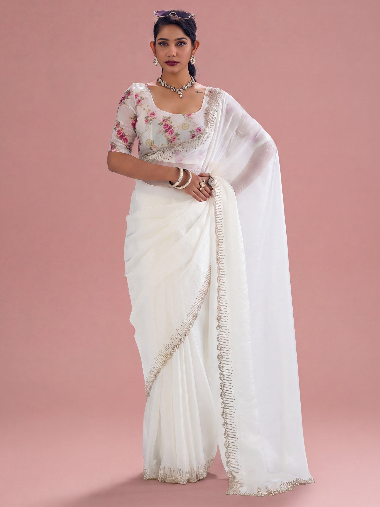 Woman wearing white silk saree with ornamented surface design and white blouse