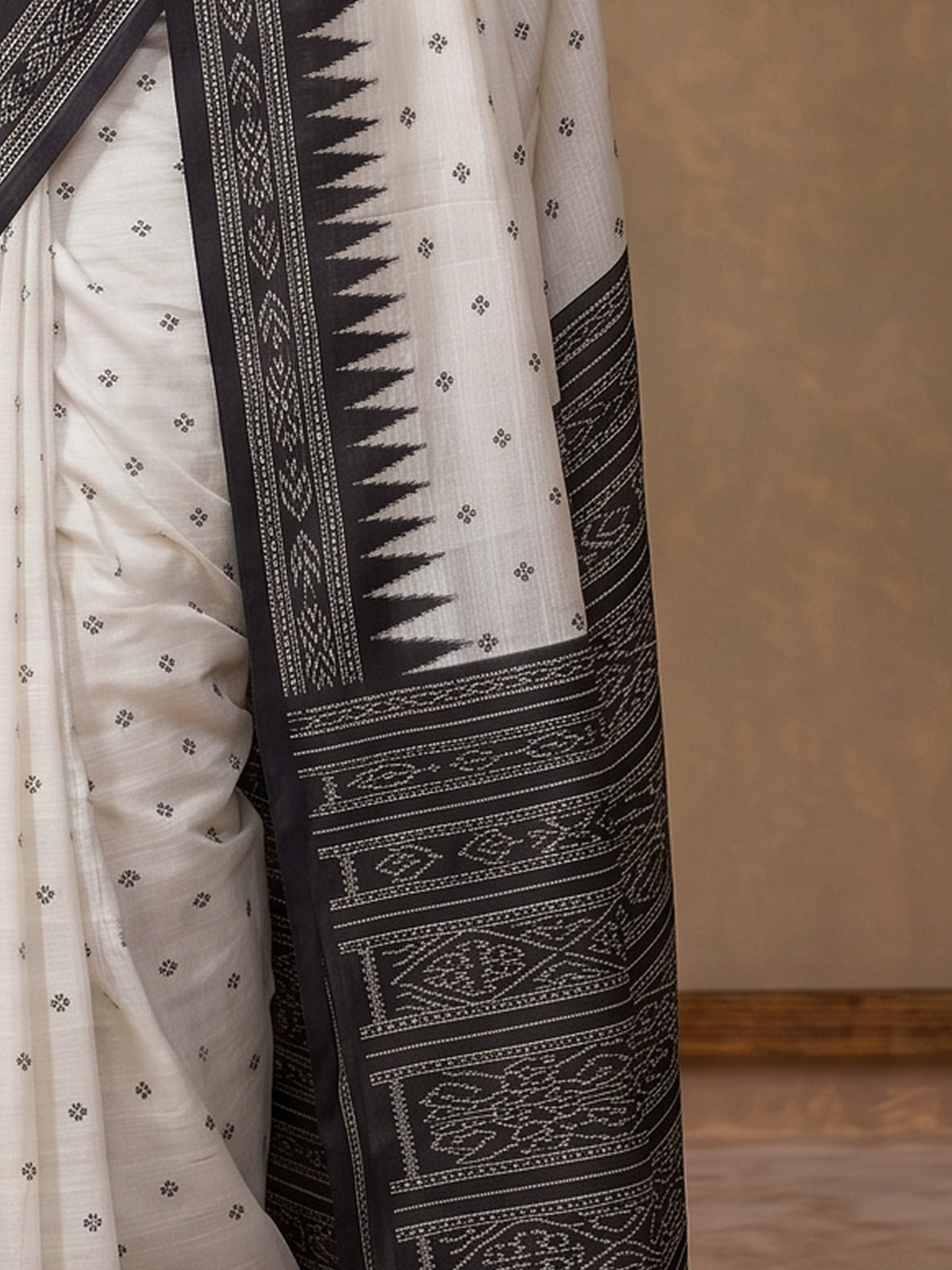 Pallu detail of off white tussar silk saree showing traditional indian motif work and printed border