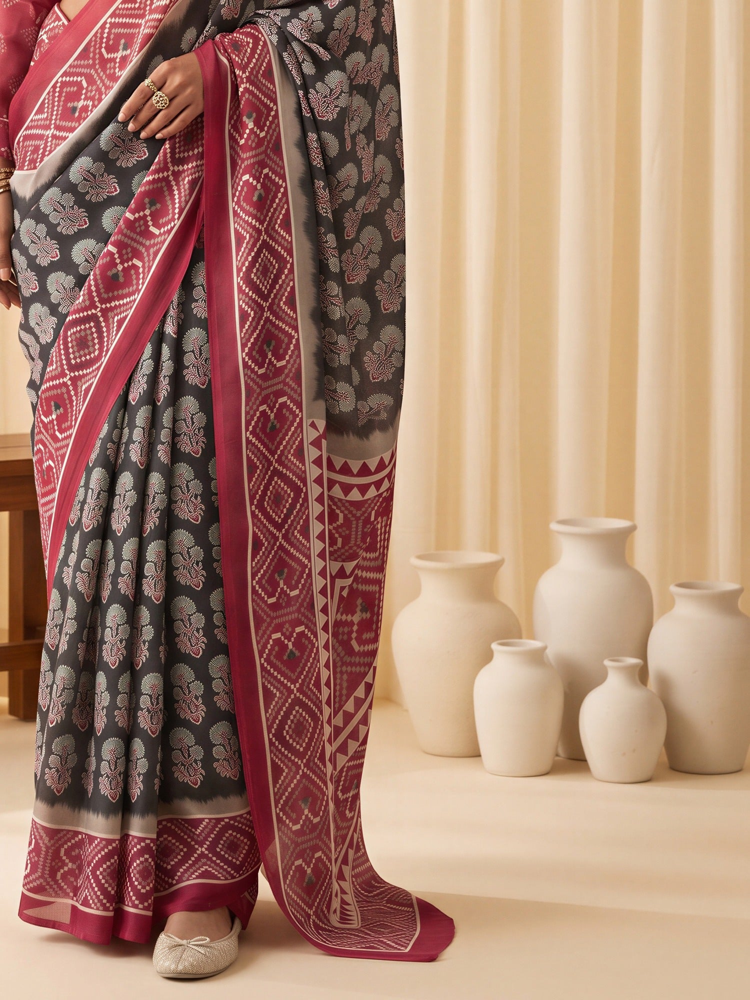 Pallu detail of black satin saree showing ajrak block-print motif work and printed border