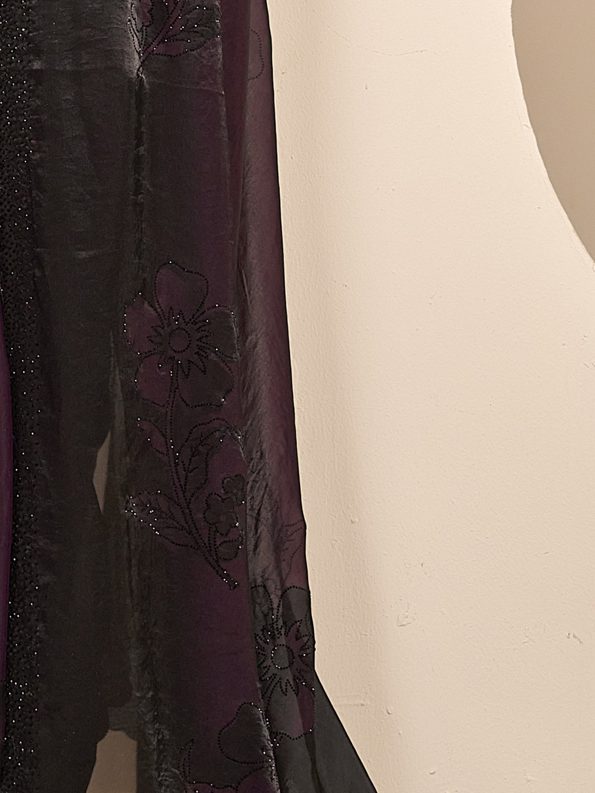 Pallu detail of wine satin silk saree showing ornamented surface design and embellished border