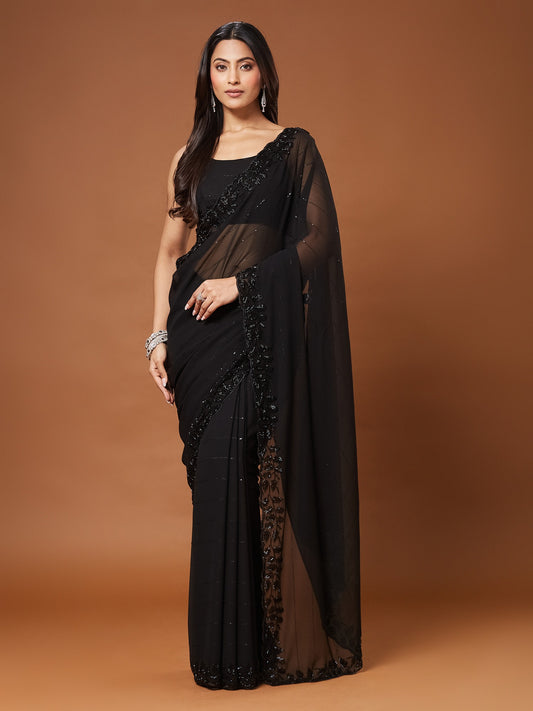 Woman wearing black georgette saree with ornamented surface design and black blouse