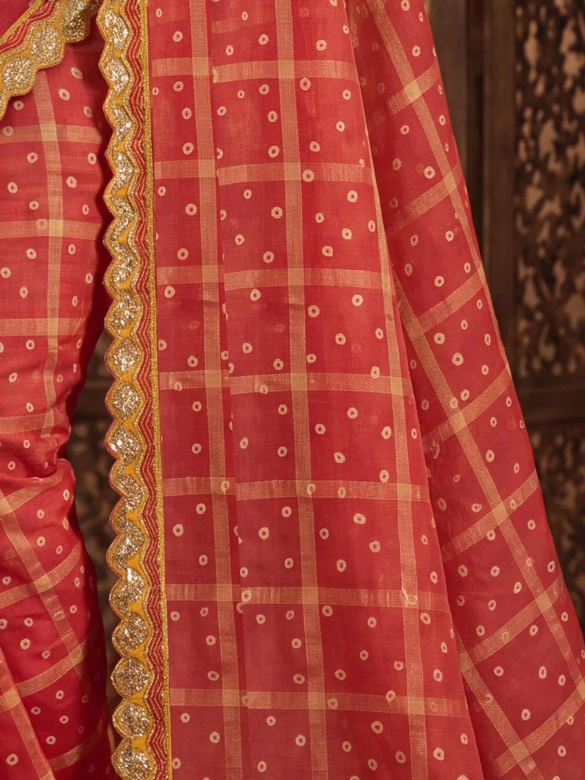 Pallu detail of red viscose saree showing bandhani tie-dye dot work and embellished border