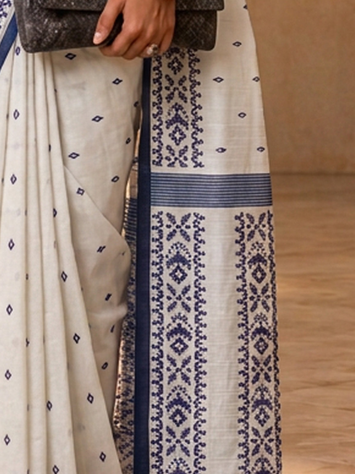 Pallu detail of off white tussar silk saree showing traditional indian motif work and printed border