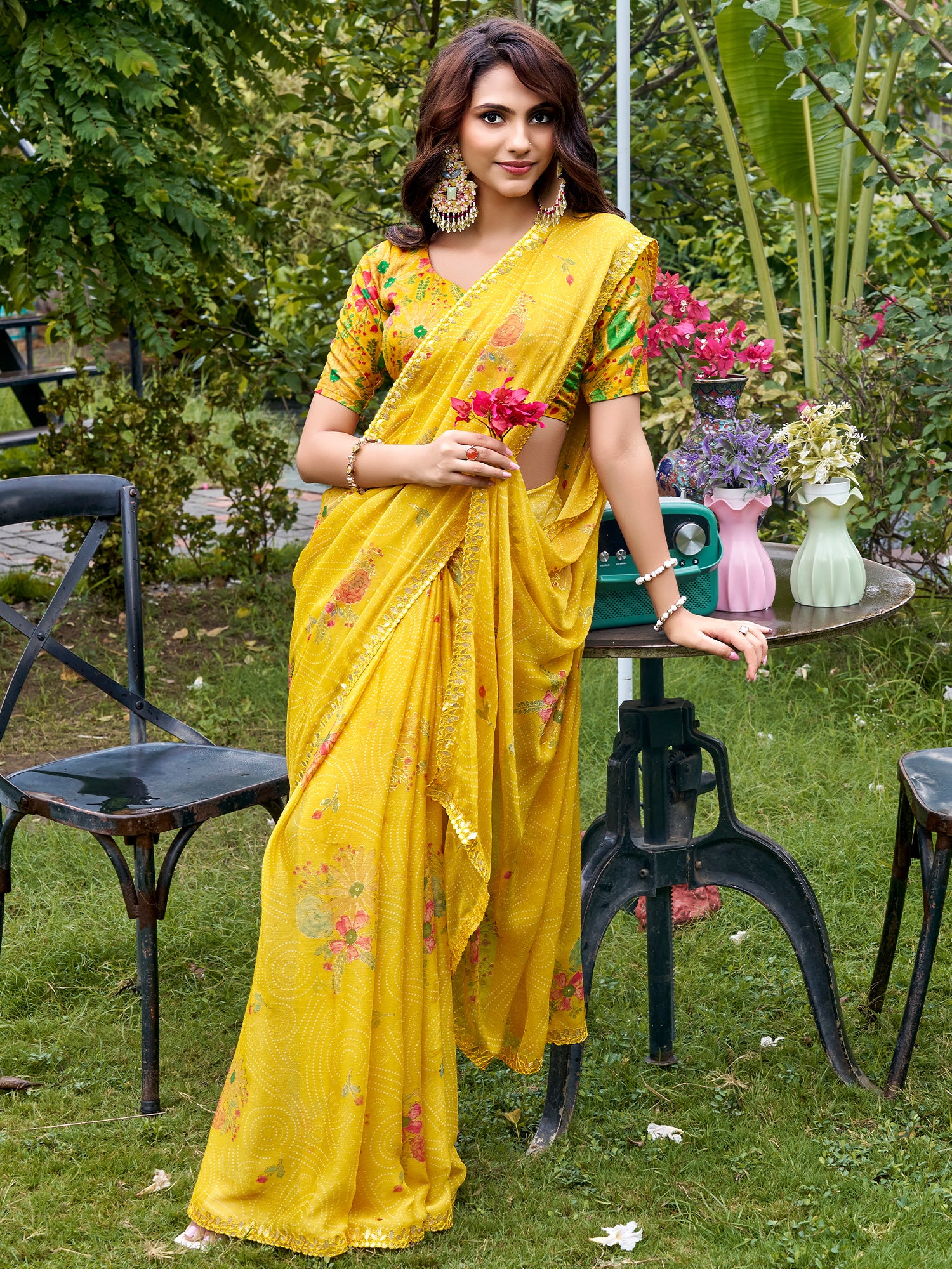 Woman wearing yellow chiffon saree with metallic foil print work and multicolored blouse