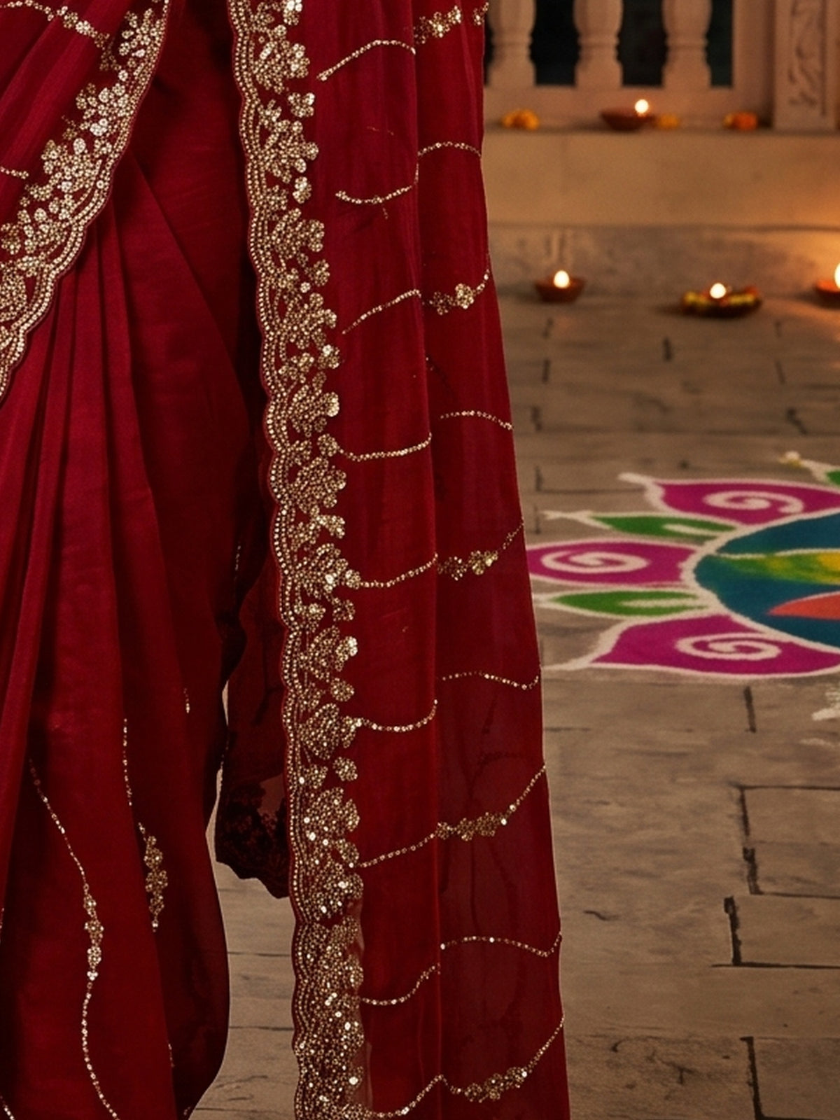 Pallu detail of red satin saree showing ornamented surface design and embellished border