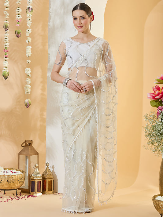 Woman wearing off white net saree with ornamented surface design and off white blouse