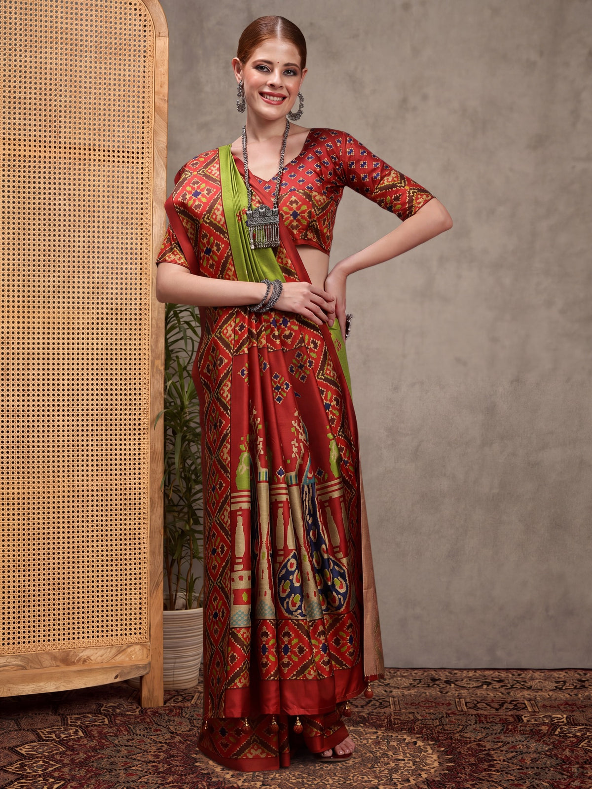 Woman wearing green silk blend saree with ikat resist-dyed pattern and maroon blouse