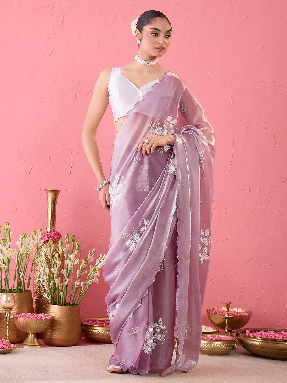 Woman wearing lavender organza ready to wear saree with ornamented surface design and white blouse