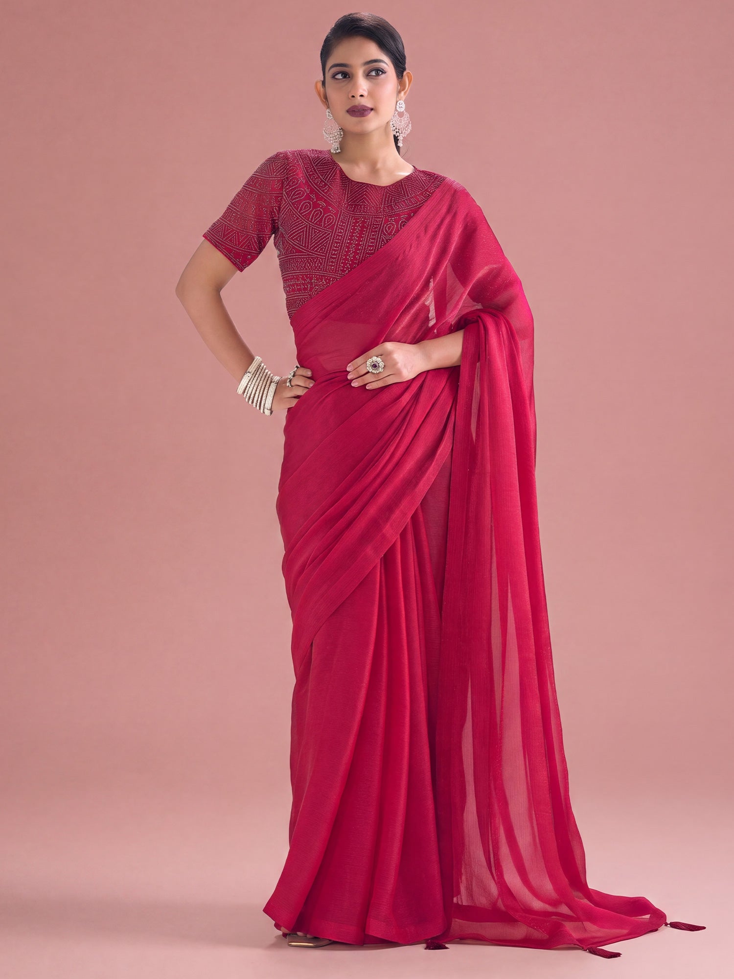 Woman wearing pink satin silk saree with clean solid-tone finish and pink blouse