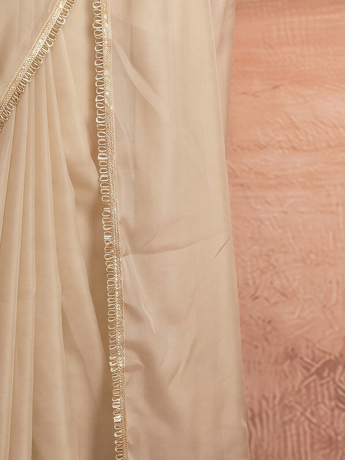 Pallu detail of cream satin silk saree showing clean solid-tone finish and embellished border