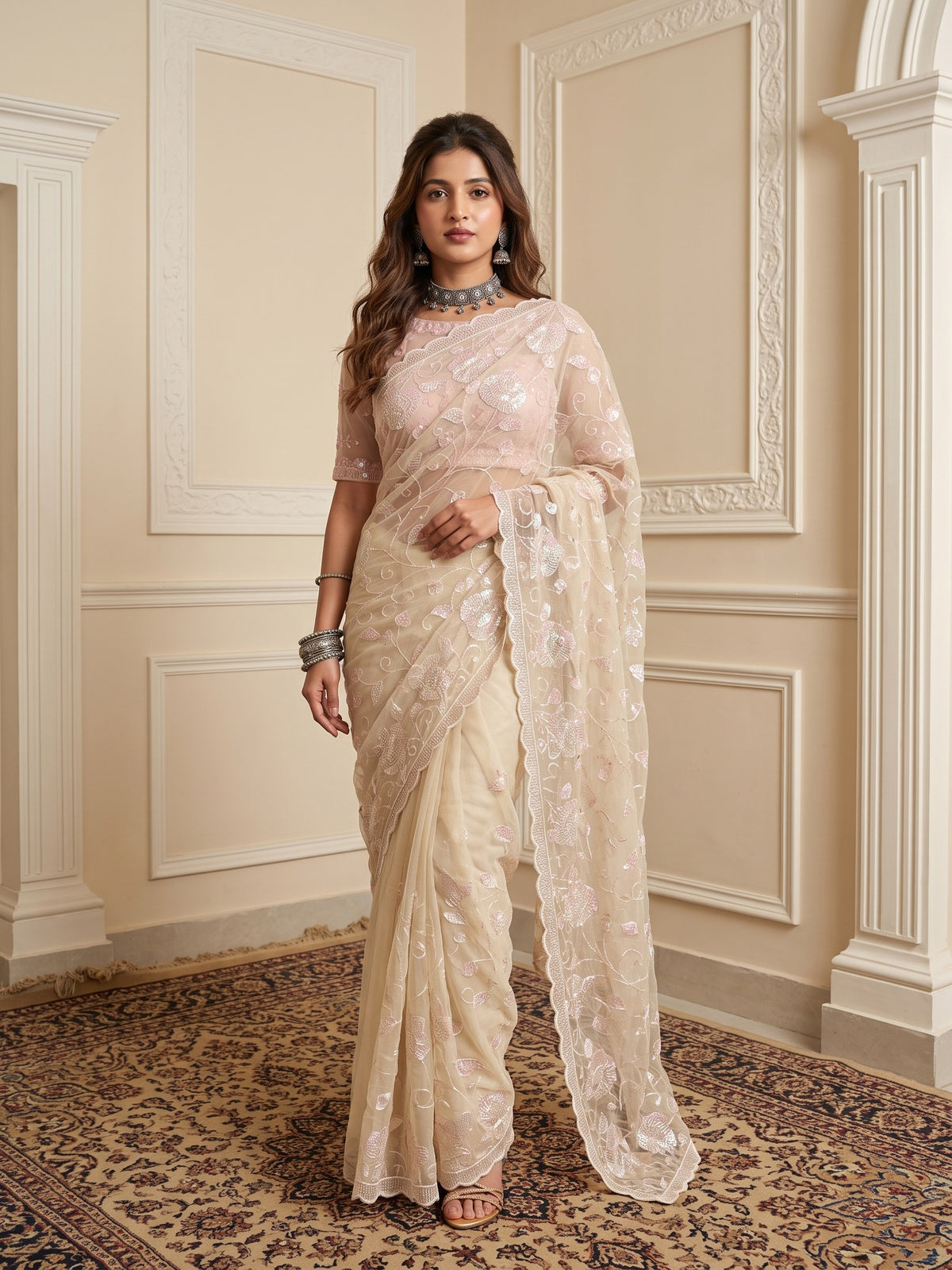 Woman wearing off white georgette saree with ornamented surface design and off white blouse